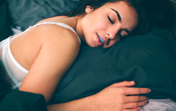 Young woman sleeping peacefully with ZQuiet anti-snoring mouthguard